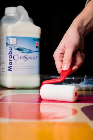 colorful image of a gallon of clearshield gloss being applied to a surface